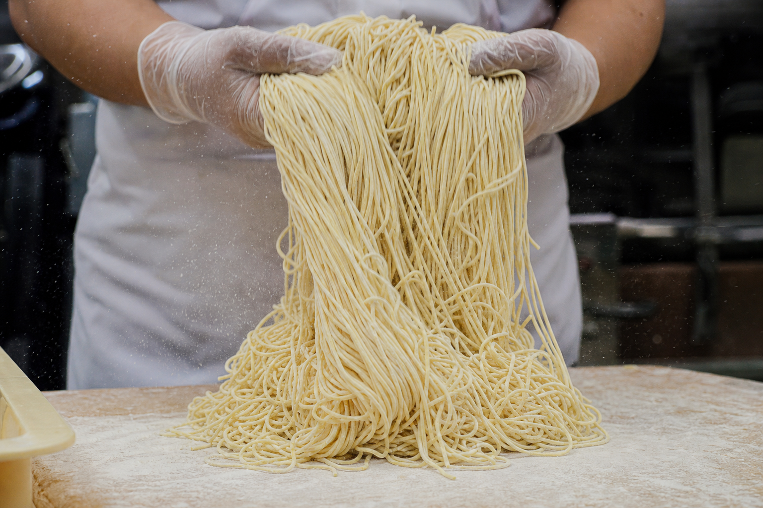 生麺を丁寧に扱う製麺工程のイメージ。